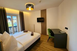 Una habitación de hotel con una cama, un escritorio y una ventana. en Hotel Krone, en Morter