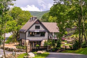 a house with a gambrel roof on a road at Bucks and Bunnies at Eagles Nest in Elk Park