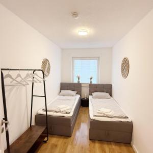a bedroom with two beds and a window at Wohlfühl-Apartment mit großem Balkon, Netflix & Games in Barsinghausen
