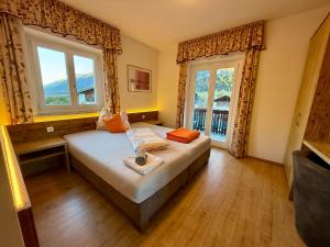 Un dormitorio con una cama y dos ventanas en Hotel Krone, en Morter