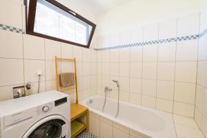 a bathroom with a washing machine and a tub at grünraum Apartment in Kleinsöding +13 photos