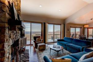 a living room with a blue couch and a stone fireplace at Hill Station in Beech Mountain