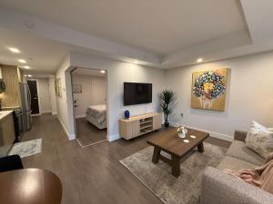 a living room with a couch and a tv at Modern and Chic One Bedroom Apartment in Downtown in Halifax