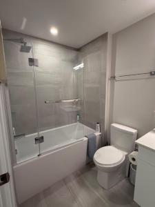 a bathroom with a tub and a toilet and a shower at Modern and Chic One Bedroom Apartment in Downtown in Halifax