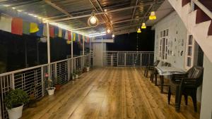 a large room with a wooden floor and a balcony at TREE HOUSE BY THE CITY ESCAPE in Shimla