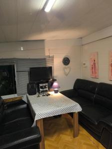a living room with a black couch and a table at BeauCamp in Rhodes