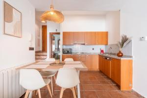 een keuken met een tafel en witte stoelen bij Suite con terraza 31E in Sierra Nevada