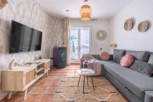 een woonkamer met een bank en een flatscreen-tv bij Suite con terraza 31E in Sierra Nevada