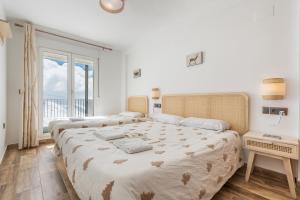 een slaapkamer met twee bedden en een groot raam bij Suite con terraza 31E in Sierra Nevada