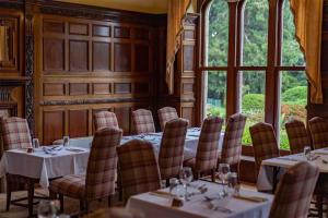 a dining room with tables and chairs and a window at Mellington Hall Country House Hotel in Church Stoke
