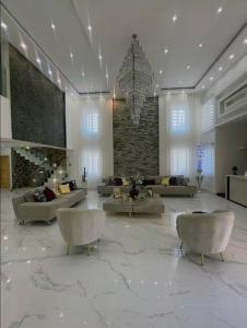a lobby with couches and chairs and a chandelier at Villa Lujosa en Boca Chica in Cuevas