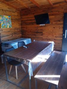 a wooden room with a table and a tv at Las Cabañas in Las Grutas