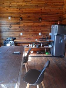 a kitchen with a table and two chairs and a refrigerator at Las Cabañas in Las Grutas