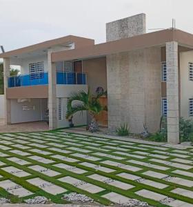 a house with a palm tree in front of it at Villa Lujosa en Boca Chica in Cuevas