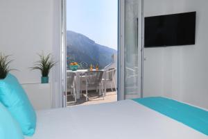 波西塔诺Villa Dei in Positano - Camere的一间带床的卧室和一个带桌子的阳台
