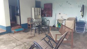 a room with chairs and a table and a refrigerator at Casa a 130 metros da praia de Boiçucanga in São Sebastião