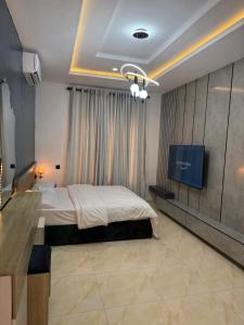 Un dormitorio con una cama y un televisor. en Luxury Haven Oral, en Ikuata