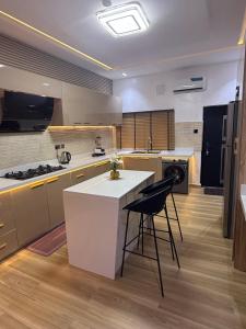 cocina con encimera blanca y nevera negra en Luxury Haven Oral, en Ikuata