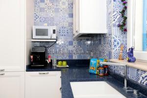 una cocina con armarios blancos y azulejos azules en Villa Dei in Positano - Camere, en Positano 4 fotos más