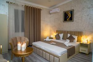 a bedroom with a bed and a table with candles at Astoria Inn in Toshkent-Passajir Bekati