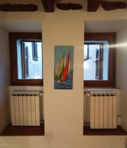 穆贾B&B Raggio di sole的一间有两扇窗户、墙上挂着两幅画的房间 更多15张照片