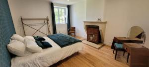 a bedroom with a bed and a desk and a fireplace at Château Puybarban in Puybarban +53 photos