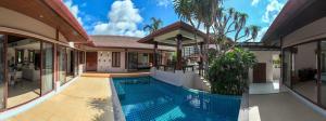 ein Haus mit einem Swimmingpool vor dem Haus in der Unterkunft Tropical Pool Villa Thai-modern Villa with an OFFICE in Phuket