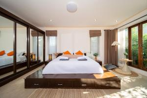ein großes Schlafzimmer mit großem Bett und großen Fenstern in der Unterkunft Tropical Pool Villa Thai-modern Villa with an OFFICE in Phuket + 77 Fotos