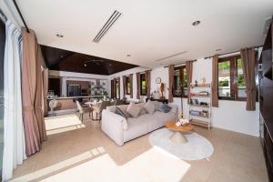 ein Wohnzimmer mit Sofa und Tisch in der Unterkunft Tropical Pool Villa Thai-modern Villa with an OFFICE in Phuket