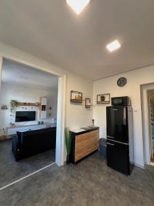 a living room with a black refrigerator and a couch at Apartmán v centru Trutnova in Trutnov +3 photos