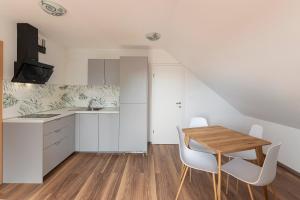 a kitchen with a wooden table and white cabinets at LOGAR Apartments in Preddvor