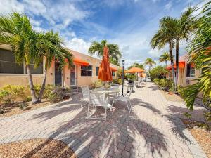 a patio with chairs and a table with an umbrella at Exclusive Studio Steps To The Beach With Pool in Hollywood Beach