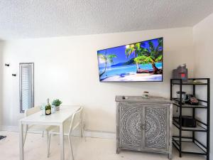 a living room with a tv on the wall at Exclusive Studio Steps To The Beach With Pool in Hollywood Beach