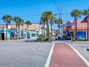an empty street in a small town with palm trees at Lazy Hammock in Tybee Island