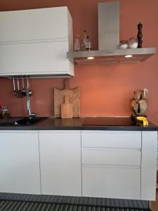 een keuken met witte kasten en een spoelbak bij A casa do Caliaru in Leonforte