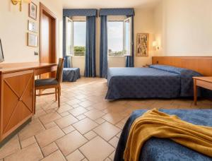 a hotel room with two beds and a desk at Hotel Giotto in Padova