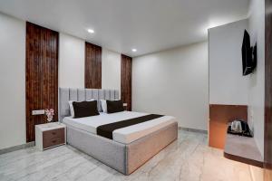 a bedroom with a large bed and a television at Townhouse DSIDC Bawana Formerly Kanhaiya Residency in Bawāna