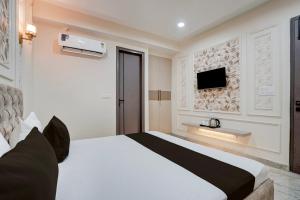 a bedroom with a bed and a tv on a wall at Townhouse DSIDC Bawana Formerly Kanhaiya Residency in Bawāna