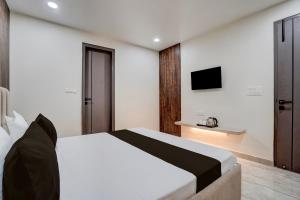 a bedroom with a bed and a tv on the wall at Townhouse DSIDC Bawana Formerly Kanhaiya Residency in Bawāna