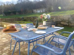 una mesa azul con sillas y una botella de vino en Gite Ar Maez, en Saint-Nolff