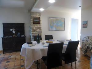 una mesa con sillas y un mantel blanco. en Gite Ar Maez, en Saint-Nolff