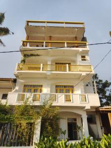 um edifício branco alto com uma varanda em The Sunset Weligama em Weligama
