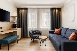 Una sala de estar con un sofá azul y una silla. en Dom-Hotel, en Worms