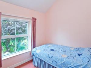 een slaapkamer met een bed en een raam bij Bridge End - E1028 in Waxham