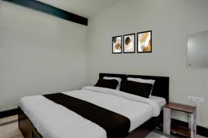 a bedroom with a large bed with white walls at Townhouse Howell Crossway Shillong Formerly Laban Guest House in Shillong +54 photos