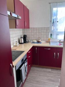 a kitchen with red cabinets and a stove top oven at Wohnung VS in Villingen-Schwenningen