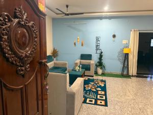 ティルパティにあるHotel O AMR Home Staysのリビングルーム(椅子、ドア付) +2枚の写真