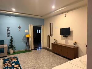 ティルパティにあるHotel O AMR Home Staysの壁にテレビが掛かっているリビングルーム