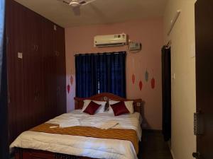 ティルパティにあるHotel O AMR Home Staysの小さなベッドルーム(赤い枕のベッド付)