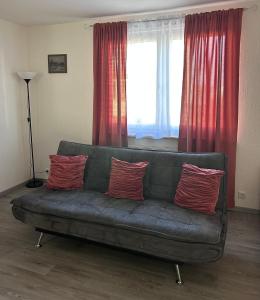 a couch in a living room with red curtains at Wohnung VS in Villingen-Schwenningen